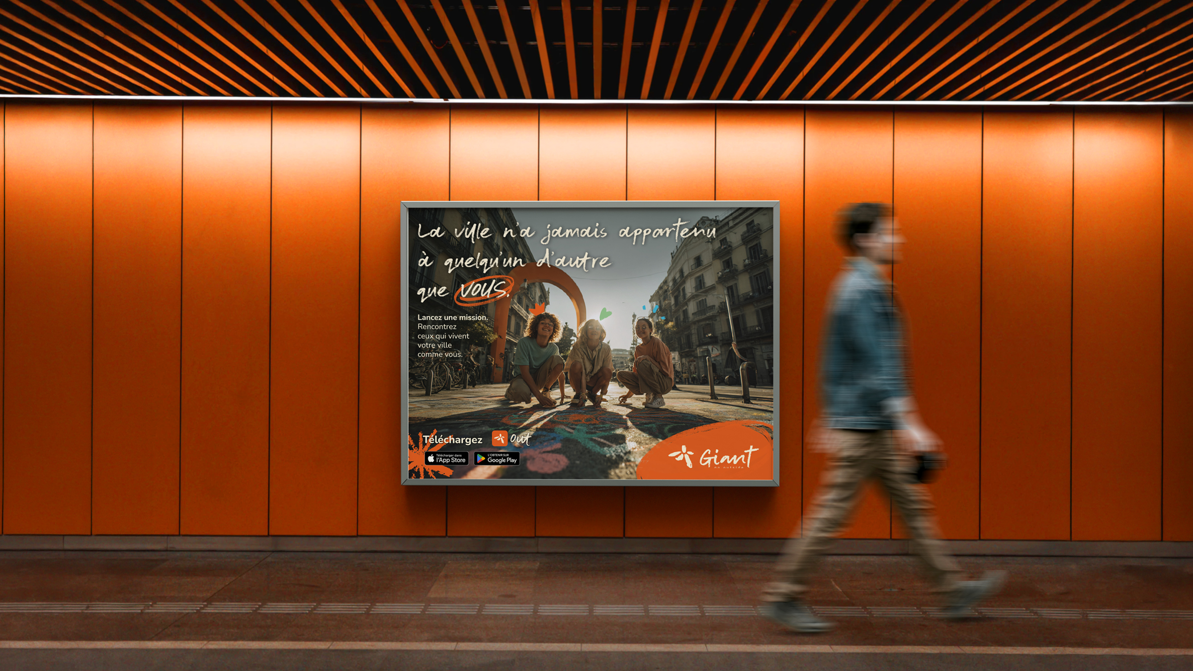 Affiche Giant « La ville n'a jamais appartenu à quelqu'un d'autre que vous » dans un couloir, un passant au premier plan
